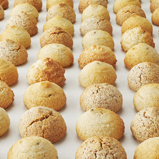 Vertical rows of golden walnutti, amaretti, pistachioretti and limonetti almond italian macaroon cookies